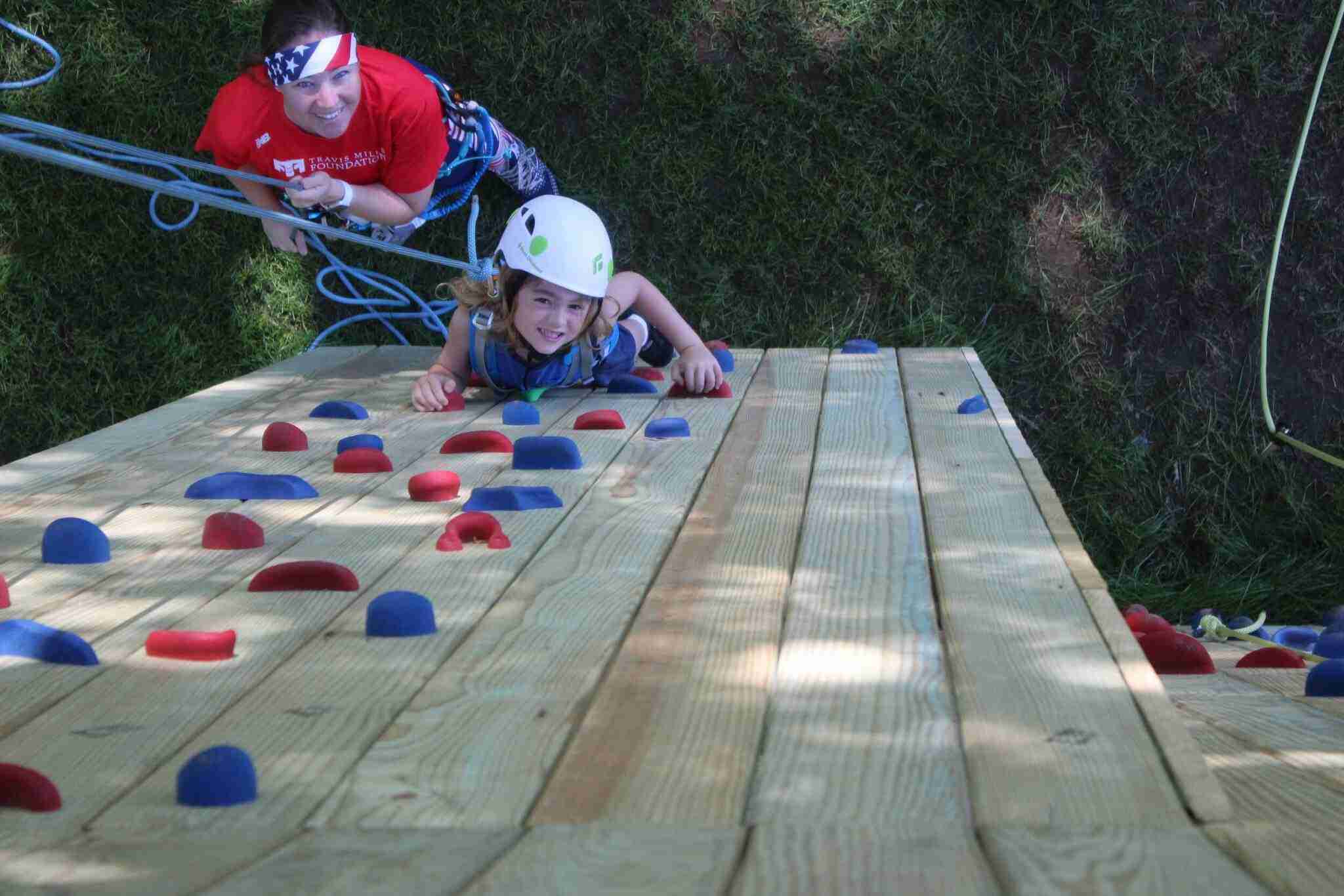 Dr. Kelly Roseberry, Program Director, leads a participant in climbing the rockwall we added to our ropes course!
