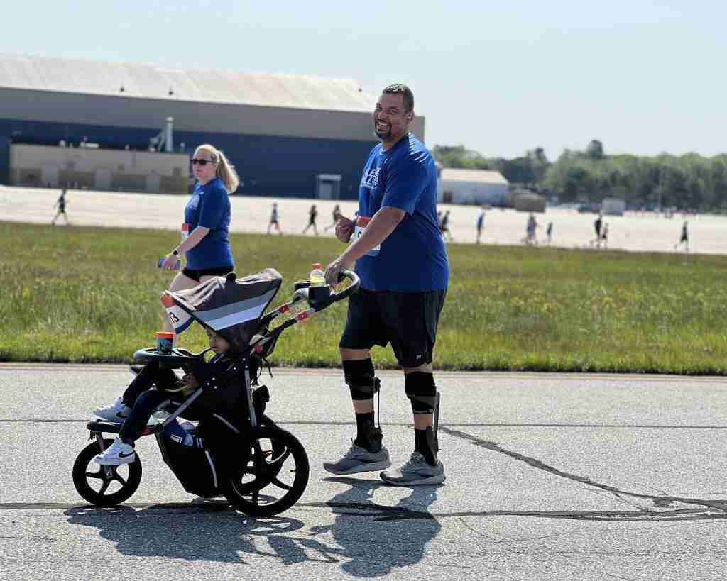a man with a stroller running smiling to the camera
