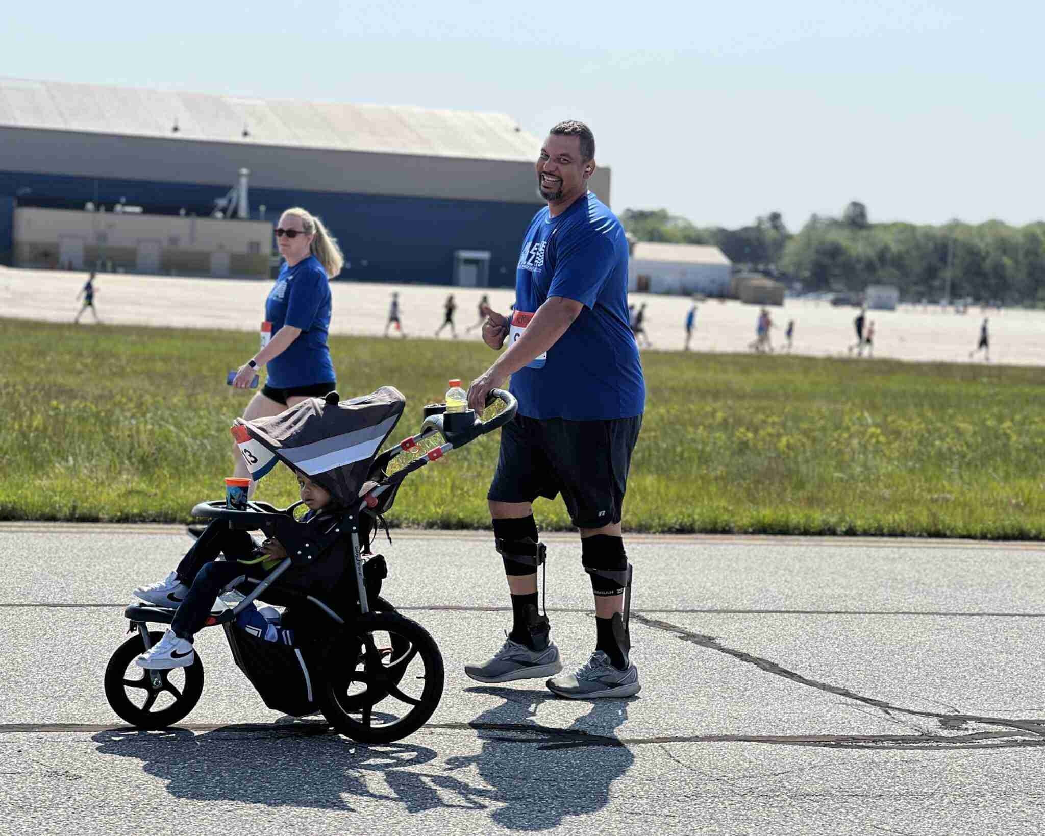 a man with a stroller running smiling to the camera