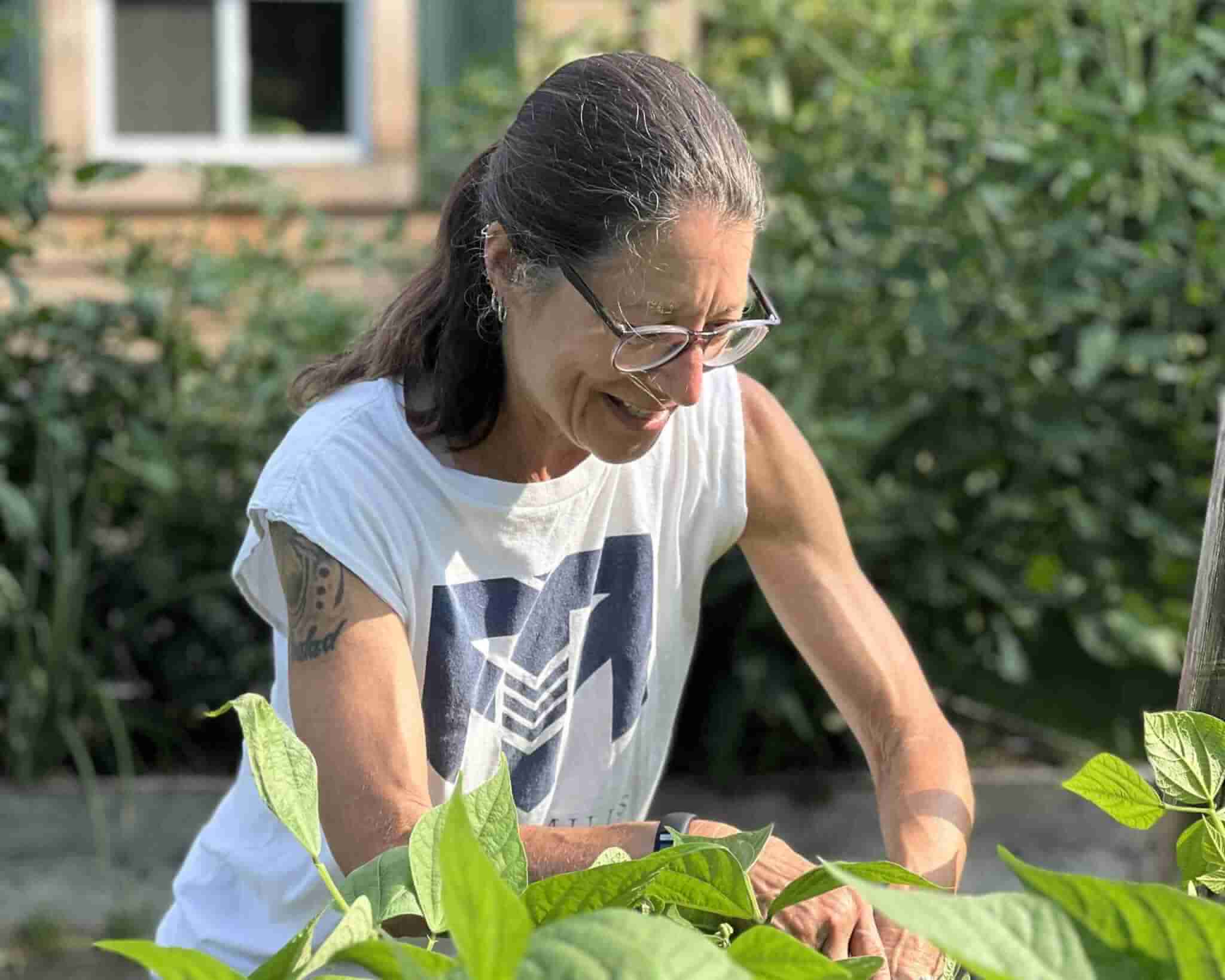 Woman in Travis Mills Foundation tending to an herb garde
